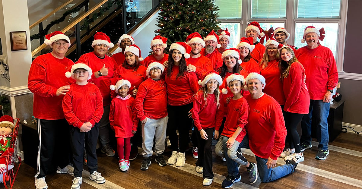 Banks Industrial Group volunteers at Ronald McDonald House of Southern New Jersey pose in front of Christmas tree that they set up